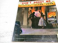 Front cover of song book featuring the album art with title 'Don't Shoot Me I'm Only the Piano Player' starring Elton John with visible wear on edges.