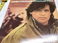 Front cover of John Cougar American Fool vinyl record showing portrait of John Cougar.
