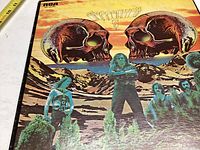 Front cover of the Steppenwolf 7 vinyl record, showing skull artwork and band members set against a mountainous landscape with a colorful sky background.