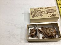 Two Wade baby tortoise ceramic figurines in cream-colored box with illustrations and text on lid.