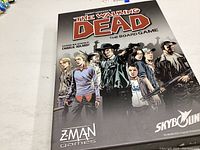 Front cover of The Walking Dead board game box showing characters from the series and branding for Z-Man Games and Skybound.