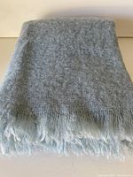 Folded pale blue/grey mohair throw showing soft texture and overall condition