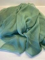 Draped view showing the soft flowing drape and texture of the sage green silk crepe chiffon fabric.