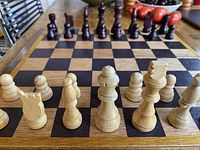 Set up chess board with pieces arranged for play showing light pieces in front.