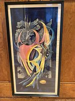 Full view of framed lithograph artwork showing abstract surrealist firebird with musical staves background, in thin black frame.