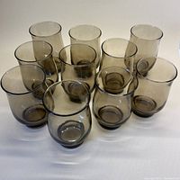 Set of 10 smokey grey/brown tulip glasses displayed showing gentle curvature and stackable bases.