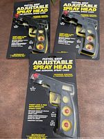 Photo showing two pistol grip adjustable spray heads in packaging along with extra nozzles.