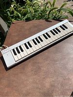 Full view of the eKeys MIDI keyboard controller showing the compact 32 keys and white plastic casing.