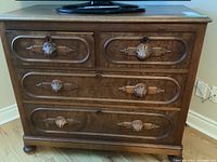 Front view of dresser showing two small upper drawers and two full-width lower drawers on bun feet