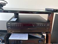 Front view of JVC XL-F254 unit with visible interface buttons and display, showing the disc tray and control buttons.