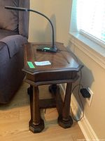 Photo showing the solid wood end table beside a couch, highlighting the top and legs.