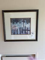 Framed print hanging on wall showing full view and frame details.