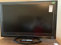 Front view of the Hitachi 37-inch Director's Series TV with remote on the stand.