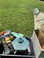 Outdoor photo showing garden gnome and mushroom garden decoration with bird feeders and boxes on grass.