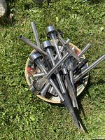 Lot of approximately 13 outdoor solar lights with silver metal stakes and clear plastic tops arranged in a bowl (bowl not included).