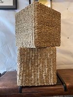 Two large square wicker baskets stacked, showing woven texture and shape
