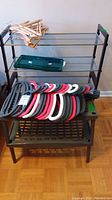 Two shoe racks around 23x11x19 and 12x29x32 inches seen stacked with multiple colored plastic hangers on top.