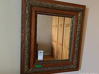 Front view of wooden framed mirror showing carved decorative border and clear reflection