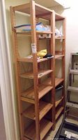 Full view of two wooden shelving units placed side by side with various items on the shelves
