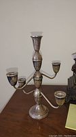 Front view of the sterling silver weighted candelabra showing five candle holders and central tall holder, surface tarnished