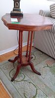 Front and top view of wooden table showing its unique curved table top and decorative legs.