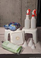 Photo showing all items: 3 mop heads, 2 spray bottles, 2 step stools, vacuum filter bag, and 3 small funnels.