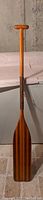 Full length wooden paddle with T-grip handle and leather wrapped midshaft.