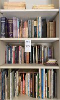 Full bookshelf with a variety of books mostly fiction and nonfiction including children's and young adult books with some classic titles on top shelf