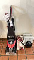 Full view of carpet cleaner with Dirt Devil boxed hand vacuum and fans beside it on tile floor.