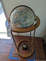 Standing globe with wooden circular supports and metal rods, vintage style map