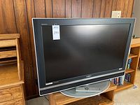 Front view of Sony Bravia KDL-V40XBR1 television with remote on stand