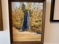 Frontal view of the oil painting showing the tree stump with surrounding autumn foliage and signature.