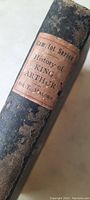 Close-up image of the spine of the book titled 'Camelot Series History of King Arthur Sir T. Malory' showing worn dark cloth binding and aged spine label.