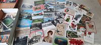 Spread of assorted antique postcards showing varied themes including holiday cards, transportation scenes, portraits, and city landscapes.