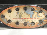 Full view of the Canadian Millennium coin set with all 12 coins arranged on a vintage style map display shaped like a maple leaf