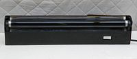 Front view of black light fluorescent lamp showing black plastic base and two tubes.