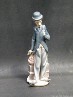 Front view of Charlie Chaplin Lladro figurine against black fabric background.