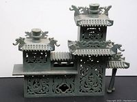 Full front view of the vintage Chinese pagoda sculpture showing its architectural tiered design and dragon motifs.
