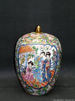Front view of oval-shaped vintage Famille Rose urn with gold-colored finial lid, detailed hand-painted scene of traditional women and floral motifs.