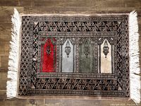 Full view of vintage small carpet showing geometric border, four-panel colored field with lantern motifs, and white fringes on two ends.