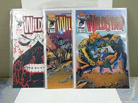 Three WildStar comic books sealed in plastic, issues #1, #2, and #3 visible from spine and partial covers.