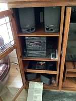 Aiwa pair of large speakers positioned above and four portable black speakers arranged below main unit
