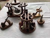 Wooden carousel rack holding eight pipes, glass-jar rack, two single-pipe stands and tabletop lighter arranged on cloth