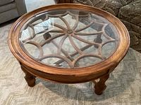 Overhead view showing circular glass inset within carved walnut wood frame and wheel motif underlay
