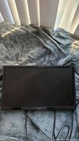 Front of Acer 21.5 inch LCD monitor laid flat on surface, screen off showing scratches and smudges
