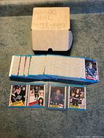 Photo showing box labeled '89-90 NHL O-PEE-CHEE Complete Set NM' and a spread of hockey cards including Joe Sakic rookie card and other players.
