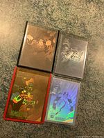 Four hologram trading cards, two DC Comics Lobo 1991 cards, one 1992 Marvel Magneto card, and one additional DC Lobo card. All in protective plastic sleeves placed on countertop.
