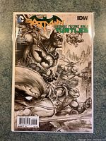 Front cover of Batman and Teenage Mutant Ninja Turtles #2 comic showing detailed black and white variant art with Batman and Ninja Turtles in action poses.