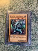 Front view of Blue-Eyes White Dragon Yu-Gi-Oh! trading card showcasing the card art and text in a protective plastic case.