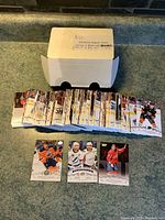 Box labeled 2018/19 Upper Deck Series 1 base set containing hockey cards, organized in stacks and spread out with visible backs and fronts featuring various players in NHL teams.